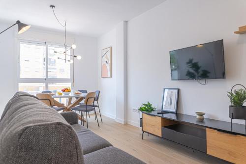 a living room with a couch and a tv on a wall at Stay In Sunset Campello in El Campello
