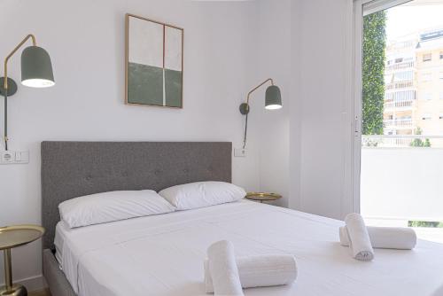a bedroom with a large white bed with two chairs at Myflats Premium Sunset Campello in El Campello