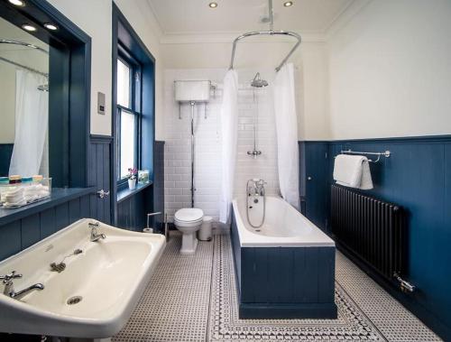 a bathroom with a tub and a sink and a toilet at Southcliff House in Portpatrick