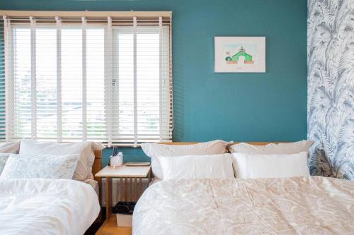 a bedroom with two beds and a table and a window at THE BLAUBAUM TOYA in Lake Toya