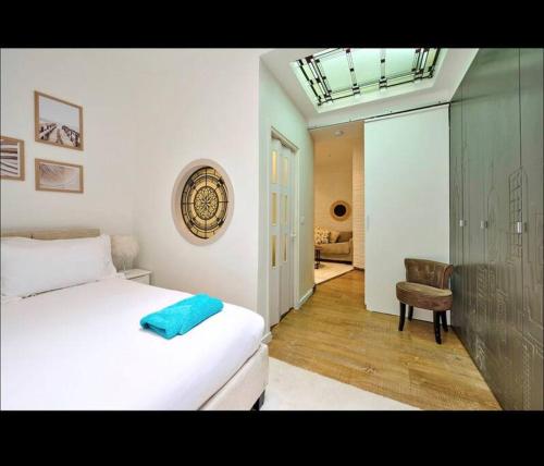 a bedroom with a white bed and a chair at Proche Roland Garros in Boulogne-Billancourt