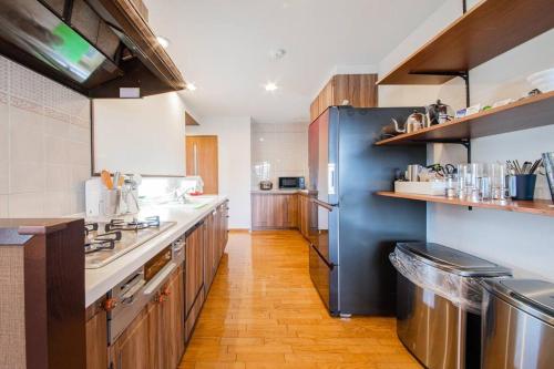 a large kitchen with wooden floors and a blue wall at THE BLAUBAUM TOYA in Lake Toya