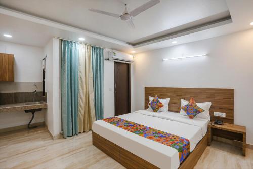 a bedroom with a large bed and a bathroom at FabHotel Unique Stay in Noida