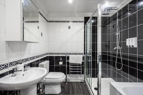 een badkamer met een toilet, een wastafel en een douche bij Elite 2 Bedroom House in Chadwell Heath/ Romford with Free Wifi and Parking upto 4 guests in Goodmayes