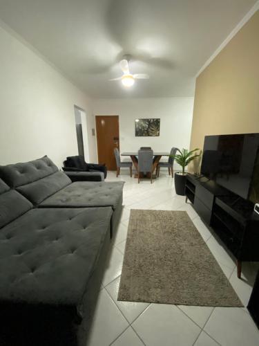 ein Wohnzimmer mit Sofa und Fernseher in der Unterkunft Apto Moderno com Churrasqueira Gourmet, apenas 150m da Praia in Praia Grande