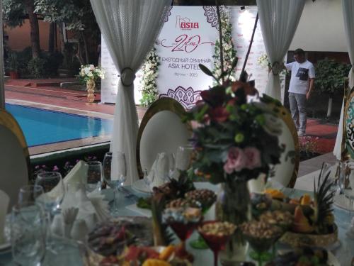 a table with a table cloth with food on it at Asia Hotel Fergana in Fergana
