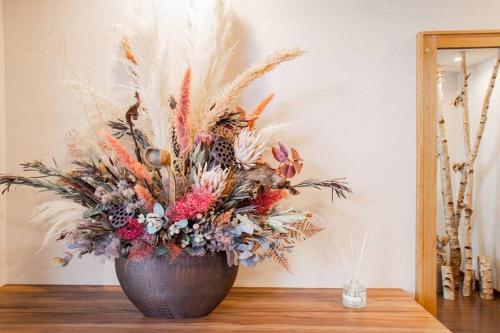a vase with a flower arrangement on a table at THE BLAUBAUM TOYA in Lake Toya