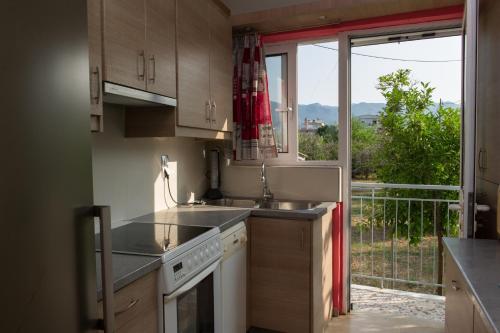 uma cozinha com um lavatório e uma grande janela em ΠΙΘΟΣ ΕΝΟΙΚΙΑΖΟΜΕΝΗ ΚΑΤΟΙΚΙΑ em Kalamata