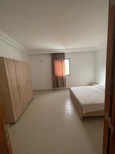 un dormitorio vacío con una cama y una ventana en Lilian en Tabarka