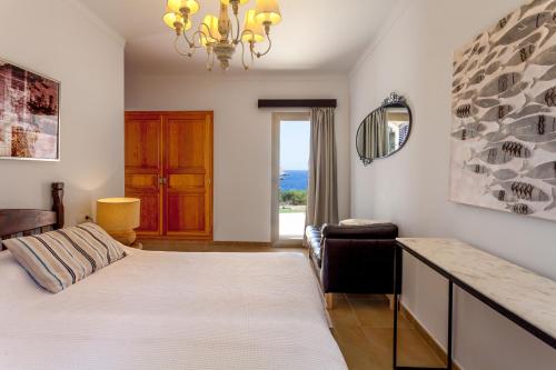 um quarto com uma cama, um sofá e um espelho em Can Ferrando de Es Pontas em Cala Santanyi