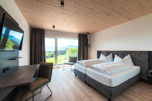 Schlafzimmer mit einem Bett, einem Schreibtisch und einem TV in der Unterkunft Landhotel Prielbauer in Mondsee