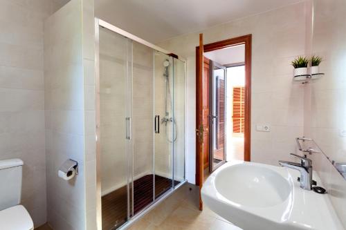 uma casa de banho com um chuveiro, um lavatório e um WC. em Can Ferrando de Es Pontas em Cala Santanyi