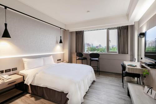 Habitación de hotel con cama y escritorio en Dolamanco Hotel, en Taipéi