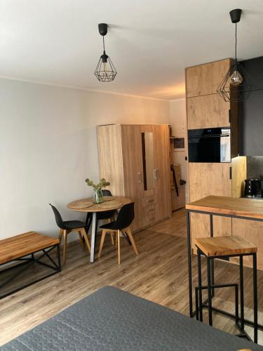 cocina y comedor con mesa y sillas en Apartament Kozigród en Tczew