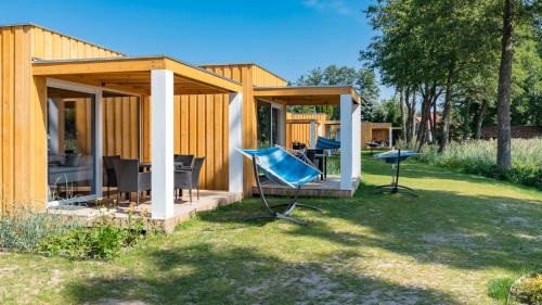 a small wooden house with chairs in the yard at Stranda in Giżycko