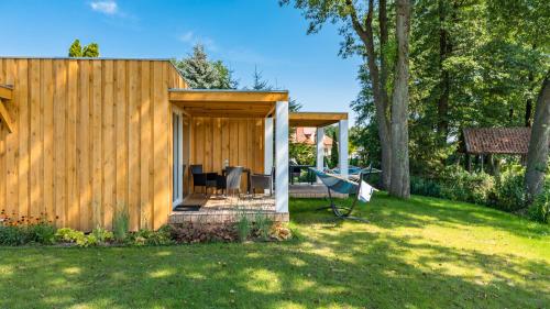 a wooden cabin with a table and chairs in a yard at Stranda in Giżycko