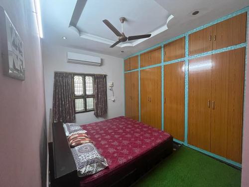 a bedroom with a bed and a ceiling fan at Vacation Rental Home in Kondapalle