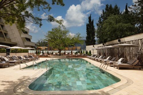 a swimming pool with lounge chairs and a building at Sheraton Grand Tbilisi Metechi Palace in Tbilisi City