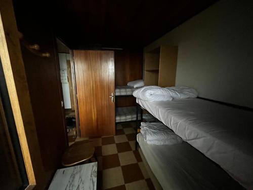 クールシュヴェルにあるl'montagne 1650のベッド2台とキャビネット付きの小さな部屋です。