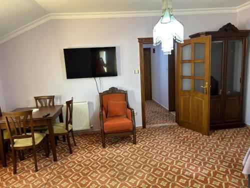 a room with a table and chairs and a tv at KARTAL APART in Pelitli