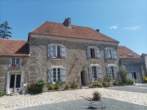 stary kamienny dom na brukowanej ulicy w obiekcie Domaine de la Ferme de Jean Grogne w mieście Fontenay-Trésigny