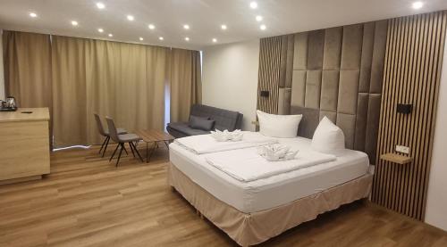 a bedroom with a large white bed and a chair at City Apart Hotel Füssen in Füssen