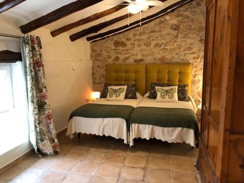 a bedroom with a large bed with a brick wall at Las Casas del Rincón- 7 dormitorios in Villahermosa