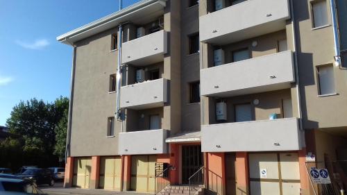 莫塔迪利文札的住宿－Monolocale Monticano，停车场内带橙色门的公寓楼