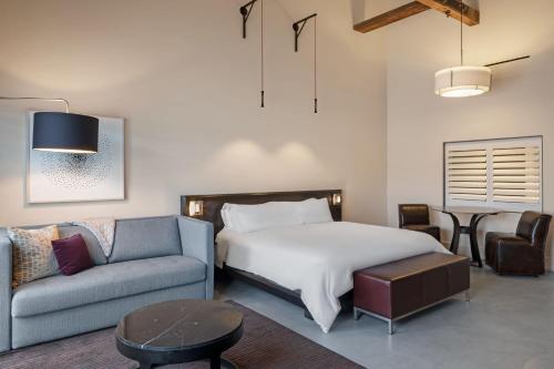 a bedroom with a bed and a couch and a table at HOTEL CERRO, Autograph Collection in San Luis Obispo