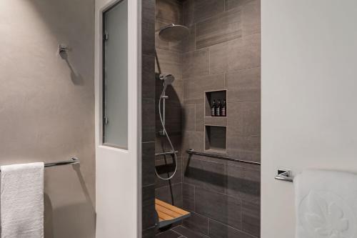 a shower with a glass door in a bathroom at HOTEL CERRO, Autograph Collection in San Luis Obispo