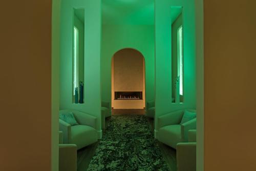 a green room with two couches and a fireplace at HOTEL CERRO, Autograph Collection in San Luis Obispo