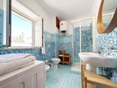 a blue tiled bathroom with a sink and a toilet at Solemar Sicilia - Palazzo Massimo in Palermo