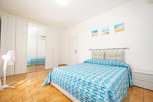 Habitación blanca con cama y espejo en Affitti Brevi Toscana - Ospitalità a Fonteblanda, en Fonteblanda