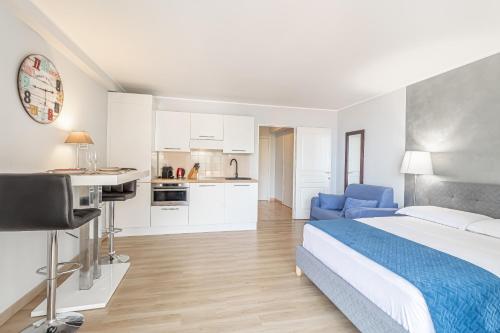 une chambre d'hôtel avec un lit et une cuisine dans l'établissement AppartHotel Jardins d’Elisa, à Beausoleil