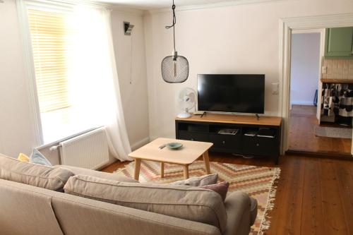 a living room with a couch and a flat screen tv at Old Town B&B Ida-Maria in Porvoo