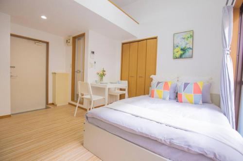 a bedroom with a large bed and a table at 閑静な住宅街_暖かく居心地の良いデザイン EoS-J in Tokyo