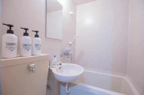 a white bathroom with a sink and a bath tub at 閑静な住宅街_暖かく居心地の良いデザイン EoS-J in Tokyo