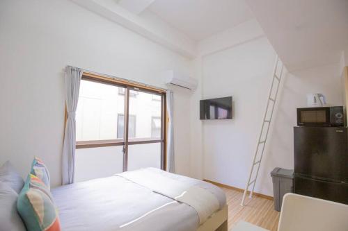 a white bedroom with a bed and a window at 閑静な住宅街_暖かく居心地の良いデザイン EoS-J in Tokyo