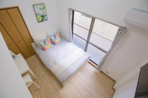 a small room with a white bed in a room at 閑静な住宅街_暖かく居心地の良いデザイン EoS-J in Tokyo