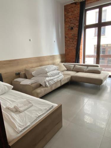 sala de estar con 2 camas y sofá en Aparthotel Łódź 55 Piotrkowska, en Łódź