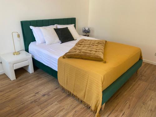 聖艾尼昂的住宿－Le Jasmin，一间卧室配有一张大床和绿色床头板