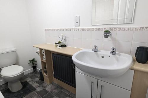 a bathroom with a white sink and a toilet at ClariTurf - 4 Bedroom Semi - Private Parking near Turf Moor, Town Centre, Transport and Motorway Links next to Canal, 3 Parks and Lake - Sky and Netflix in Burnley