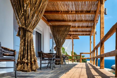 une terrasse en bois avec une table et des chaises et l'océan dans l'établissement Selene, à Armenistis