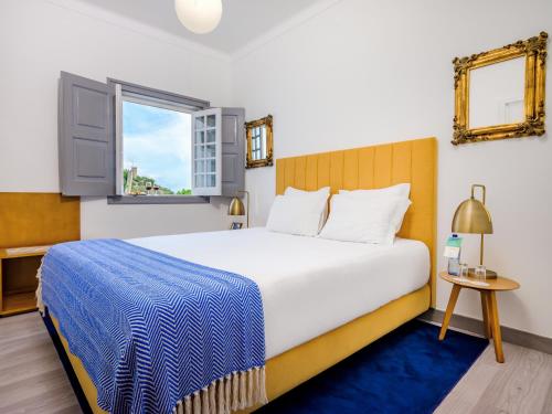 a bedroom with a large bed and a window at Casa Senhoras Rainhas - Óbidos - by Unlock Hotels in Óbidos