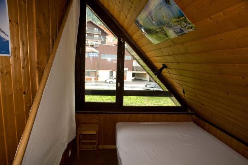 Cette petite chambre avec fenêtre se trouve dans une maison en bois. dans l'établissement Duplex Le Yéti 16 Station Thollon les Mémises, à Thollon-les-Mémises