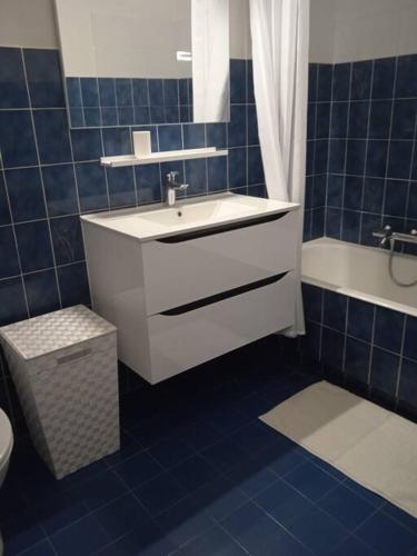 La salle de bains est pourvue de carrelage bleu, d'un lavabo et de toilettes. dans l'établissement Antibes Quiet studio air-condit-swim. pool tennis, à Antibes