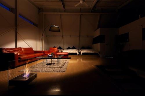 a living room with a couch and a table and a bed at MS STUDIO in Asahikawa