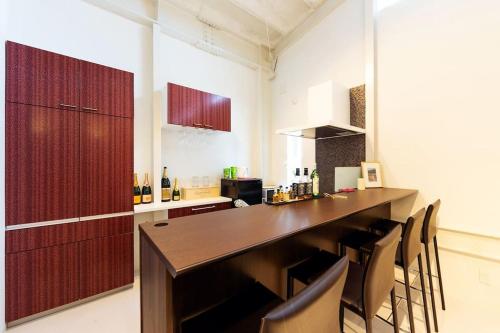 a kitchen with a large wooden bar with chairs at MS STUDIO in Asahikawa