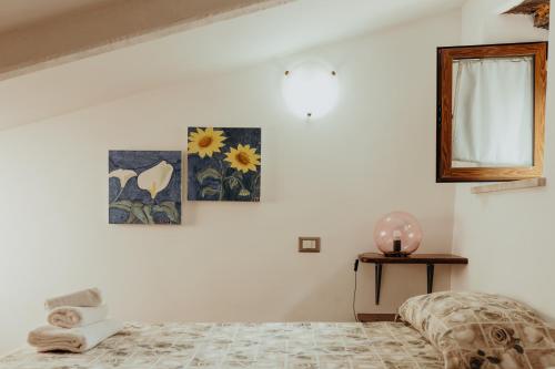 una camera con un letto e alcune immagini sul muro di La Dolce Vita Fidardo a Pitigliano