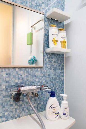 a bathroom sink with two bottles of soap and a mirror at MS STUDIO in Asahikawa